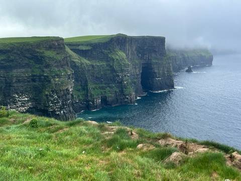 Cliffs of Moher with mist and dramatic views of the sea.