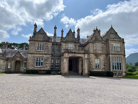 Historic stone mansion with green shutters.