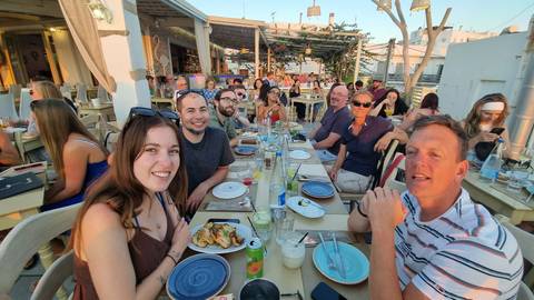 Group of people dining at a beachfront restaurant.