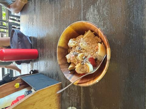 Bowl of fruit and cereal on a wooden table.