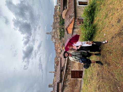 Couple posing with an umbrella in a scenic town.