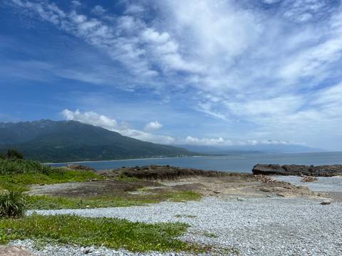 Scenic coastal landscape with mountains in the distance.