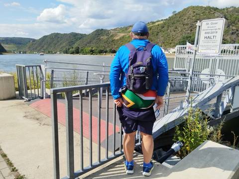 A man standing near a riverfront with scenic views.