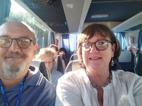 A couple sitting inside a bus, smiling.