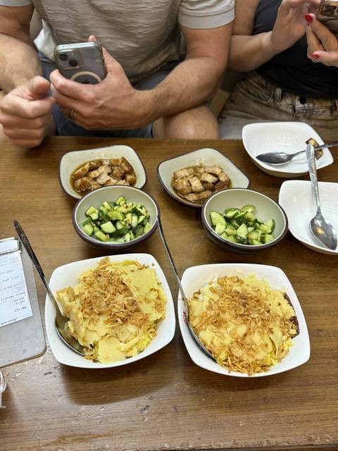 A table set with various Vietnamese dishes including tofu and cucumber.
