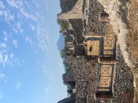 Ruins of an ancient city with a mountainous backdrop.