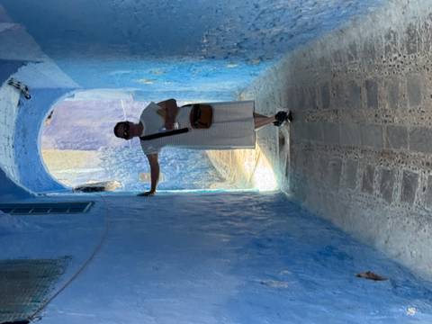 Person standing in a narrow blue alleyway.