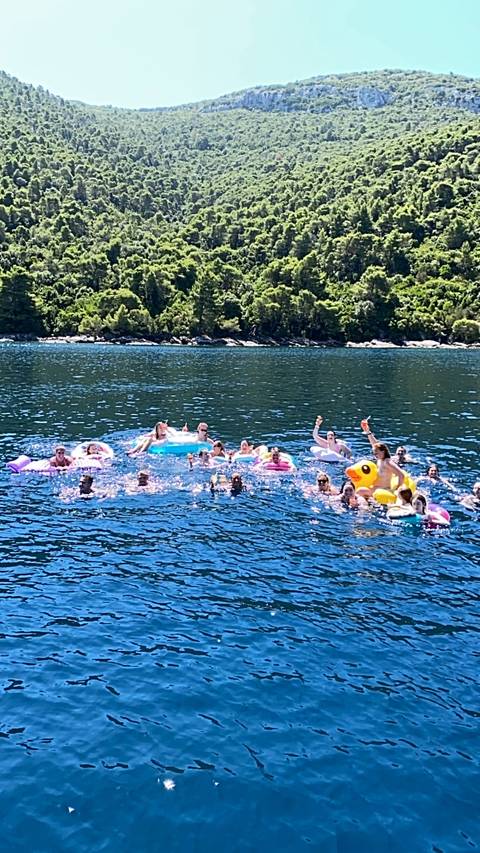 People swimming with inflatable rafts in the sea.