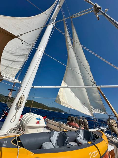 Sails of a boat against blue sky and sea.