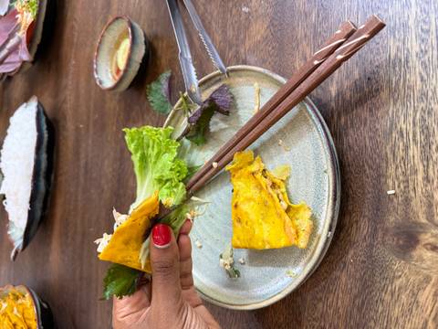 A plate with partially consumed food using chopsticks.