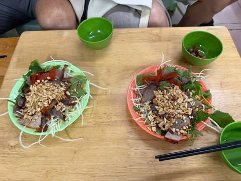 Two plates of Vietnamese noodle salad on a wooden table.
