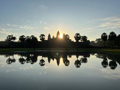 Angkor Wat with a sunrise reflection in the pond.