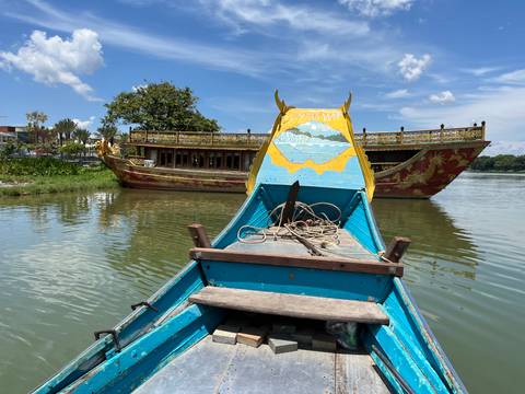 Dragon boats on a calm waterway under a clear blue sky.