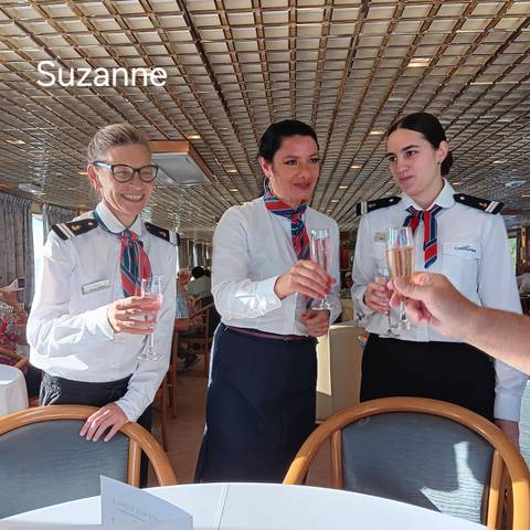 Women in uniform toasting with drinks.