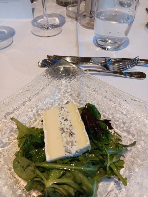 Cheese plate decorated with greens.