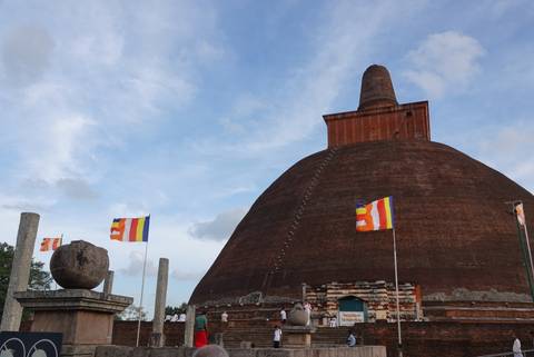 Ancient stupa with colorful flags in Anuradhapura.