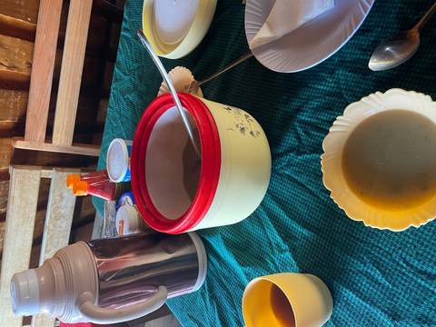 Table setup with bowls and thermos containing soup.