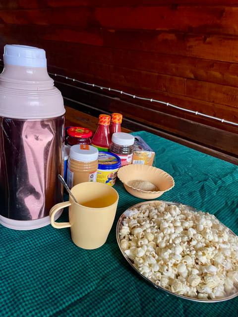 Table with various food items and condiments including a flask, cups, and jars.