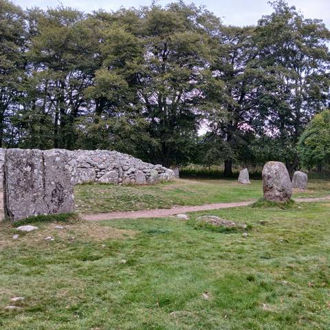 Stone structure with scattered rocks and standing stones.