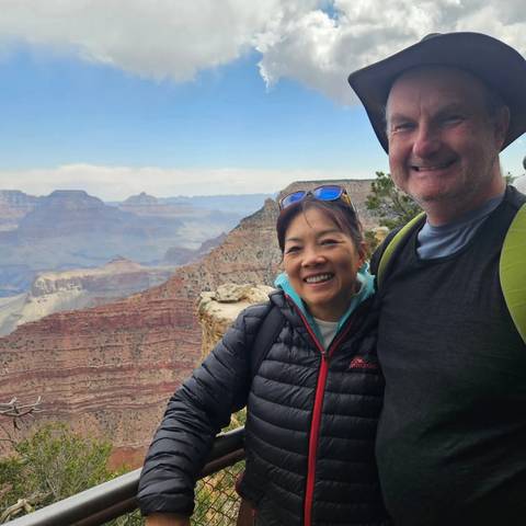 Two people posing with a grand canyon as the backdrop.