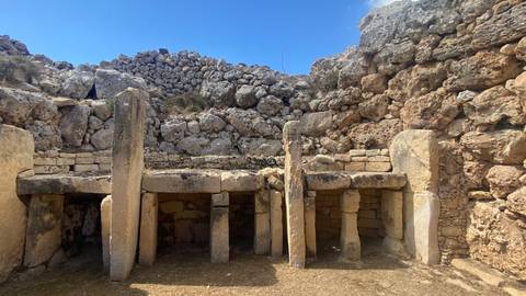Ancient stone ruins under a clear blue sky.