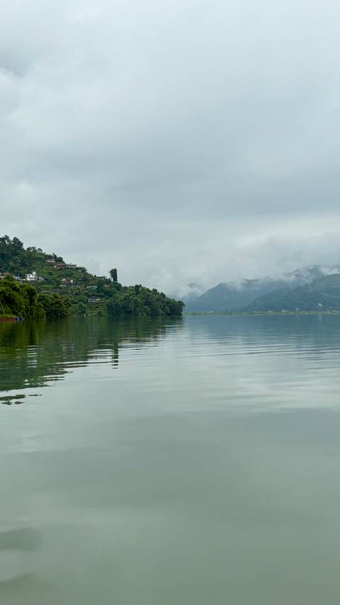 A misty lake with hills and trees in the background