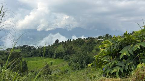 Scenic hillside landscape with clouds and distant mountains