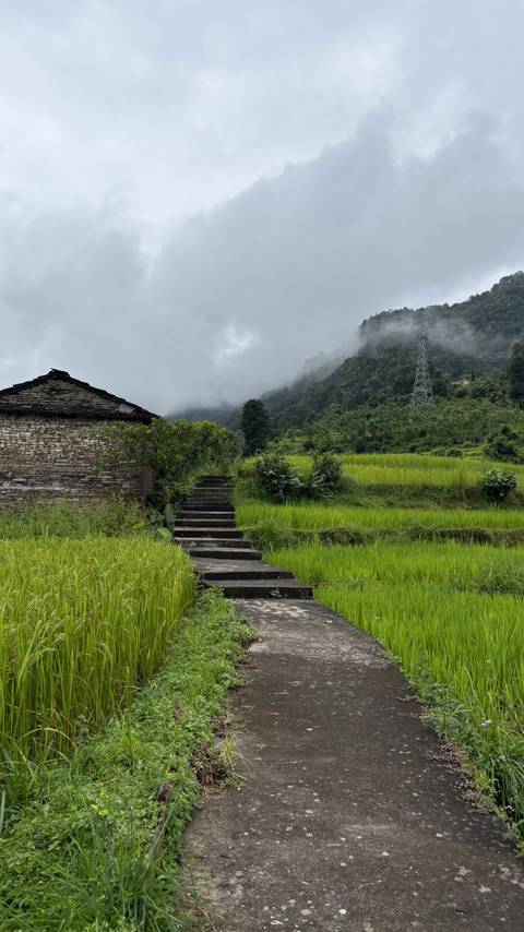 Steps leading to a stone house with fields