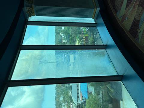 View through a window overlooking a city with buildings.