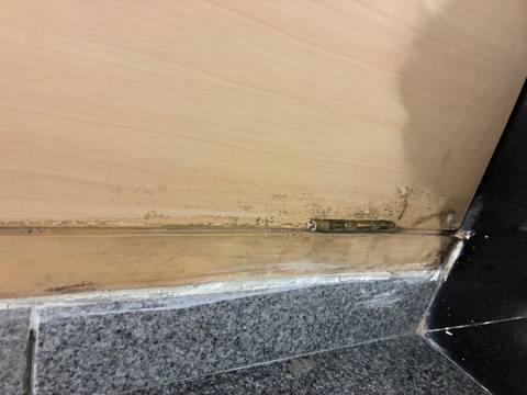 Door hinge with peeling paint and grime.