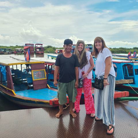 Tourists standing beside boats.