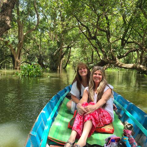 Tourists on a boat in a lush forest.
