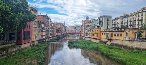 A river flowing through a city with vibrant buildings on each side.