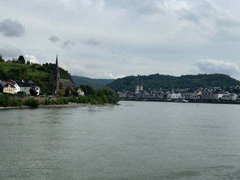 Scenic view of a town by the river with distant hills.