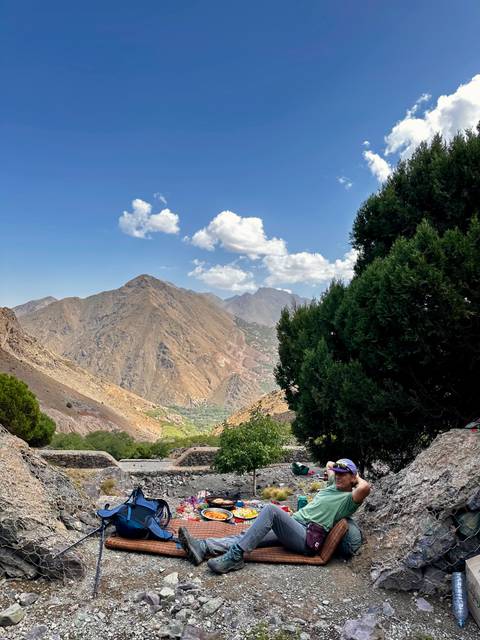 Mountain range under a clear blue sky with clouds.