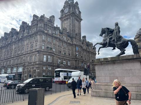 A historic building and equestrian statue in a city setting.