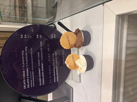 Ice cream cups with wafer cookies displayed on a counter.
