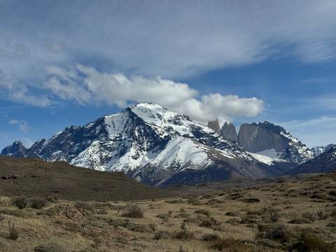 Majestic mountain range with a clear blue sky and dry foreground.