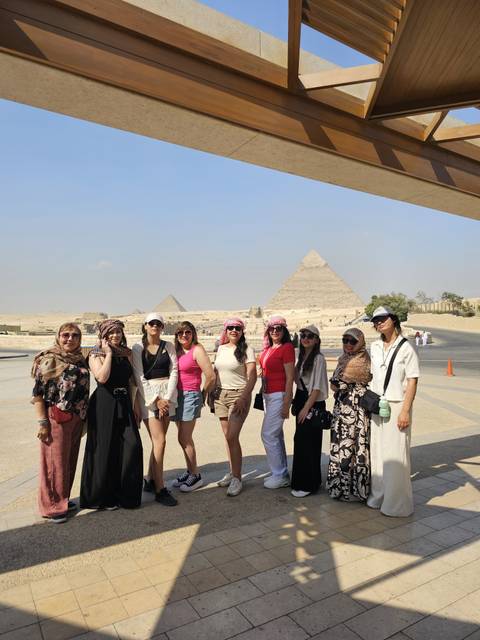 A group of people posing in front of the pyramids.