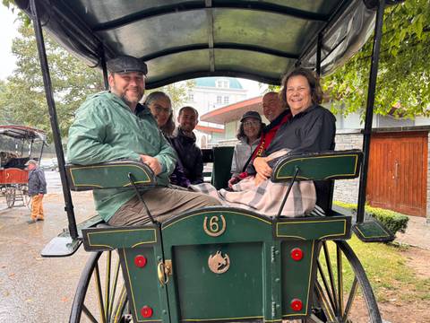 Group of people in a horse-drawn carriage.