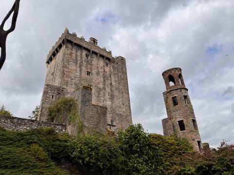 Ancient stone castle towers against a cloudy sky.