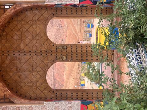 Decorative wooden doorway with a view of desert landscape.