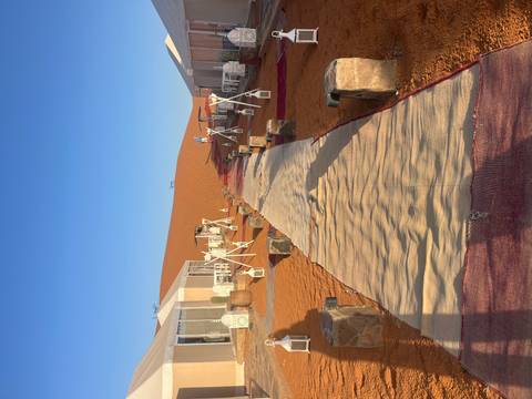 Luxury tent accommodation in the desert with a red carpet.