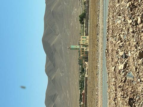 Mosque in a desert landscape with mountains, Morocco.