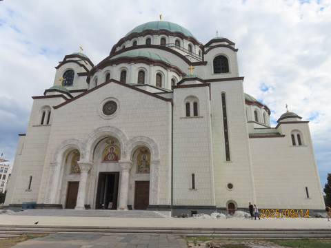 St. Sava Church with a cloudy sky.