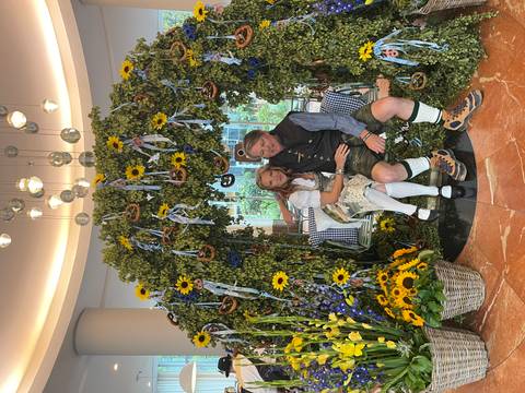 Couple seated in a decorative floral archway.