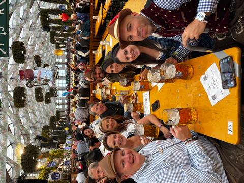 Group seated at a festival table with beers.