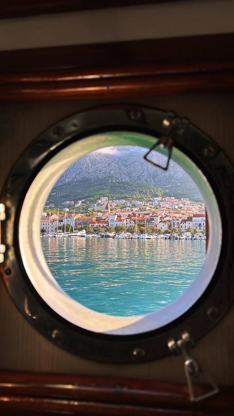 View of a coastal town seen through a porthole.