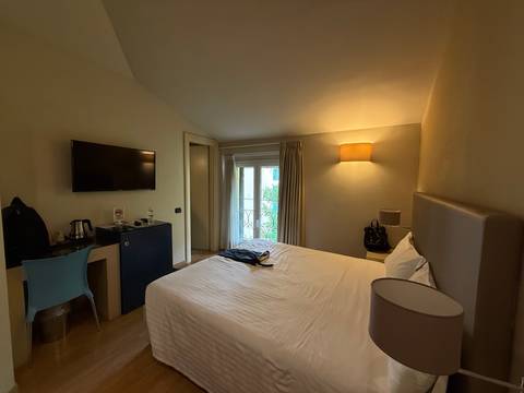 Interior of a hotel room with a bed and television.