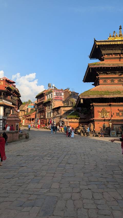 Bustling street with historic architecture and people walking.
